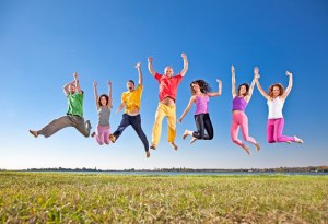 People happily jumping in the air with their arms held over their heads
